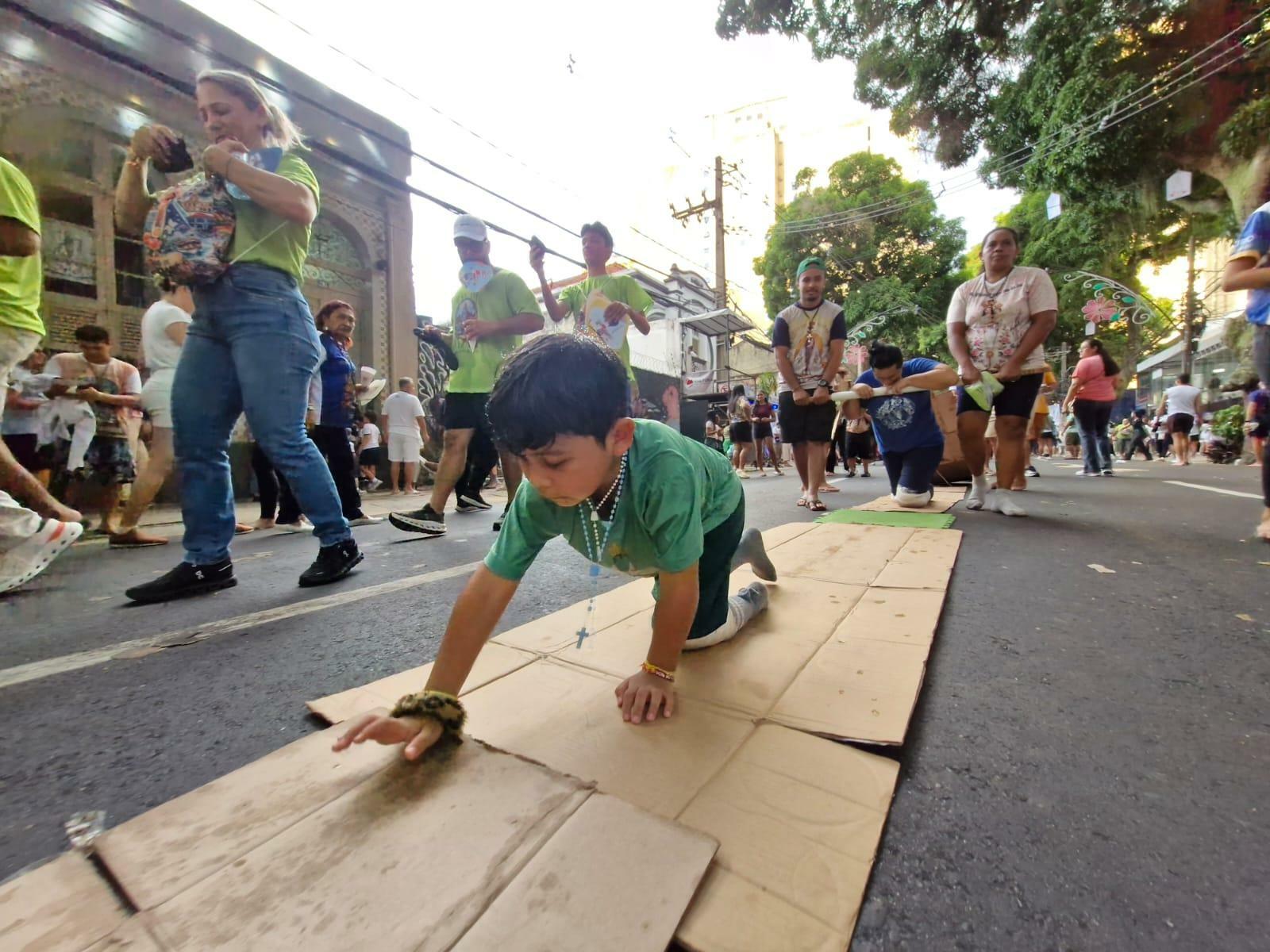Menino vai junto da mãe pela avenida Nazaré